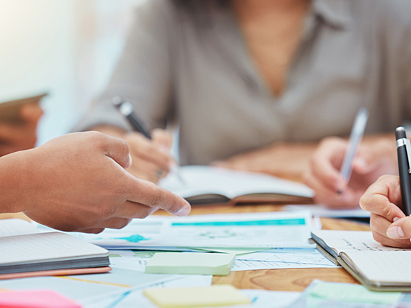 people working together and taking notes and reviewing documents